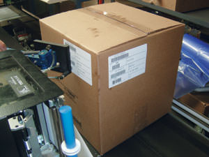 A custom-manufactured tamp pad places a label onto the side panel of a case.